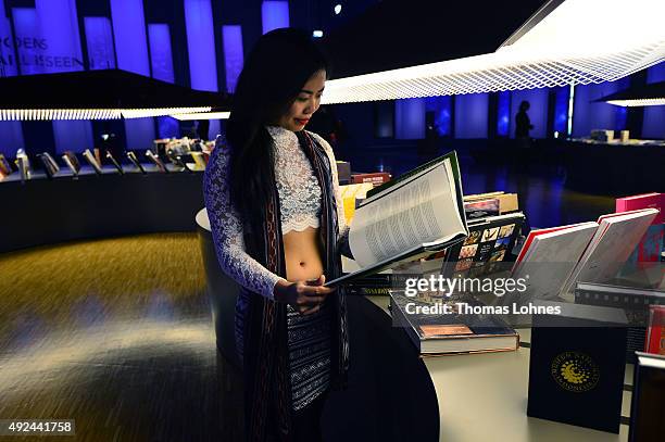 The 'political youtuber' Wita Wanita looks through a book at the exhibiton of the guest country Indonesia at the 2015 Frankfurt Book Fair on October...