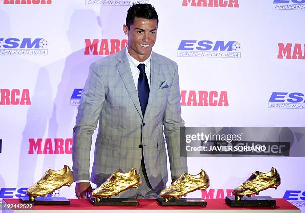 Real Madrid's Portuguese forward Cristiano Ronaldo poses with his European Golden Shoes after receiving the fourth one, on October 13, 2015 in...