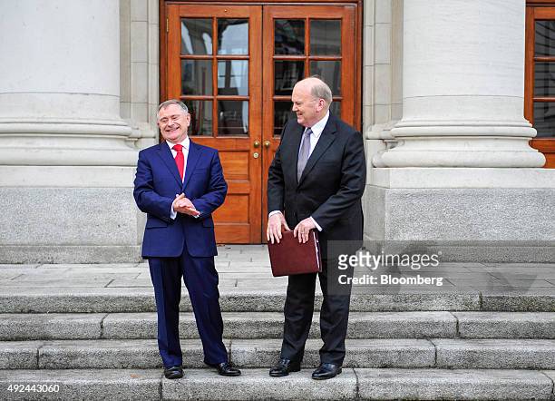 Michael Noonan, Ireland's finance minister, right, and Brendan Howlin, Ireland's public spending minister, react on the steps of the government...