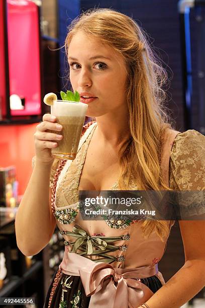 Model poses with a glass of coffee during the opening of the smallest pop-up cafe in town by NESPRESSO on October 13, 2015 in Munich, Germany.