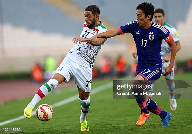 Ashkan Dejagah and Hasebe Makoto in action during the international friendly match between Iran and Japan at Azadi Stadium on October 13, 2015 in...