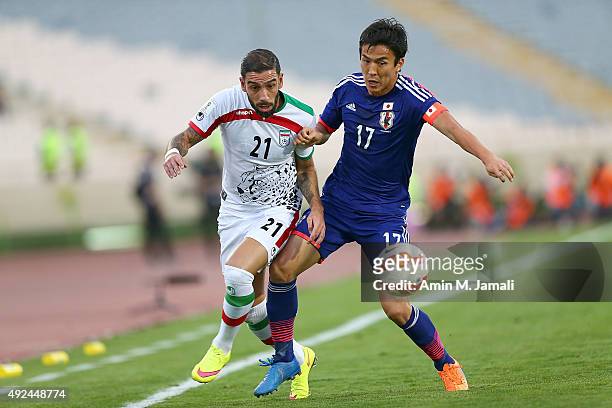 Ashkan Dejagah and Hasebe Makoto in action during the international friendly match between Iran and Japan at Azadi Stadium on October 13, 2015 in...