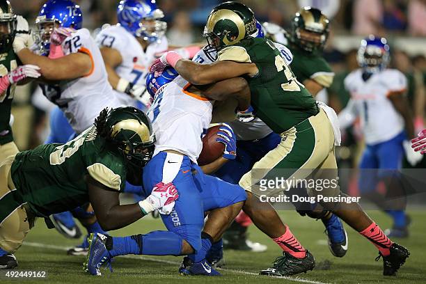 Jeremy McNichols of the Boise State Broncos is tackled by Terry Jackson of the Colorado State Rams and Kevin Davis of the Colorado State Rams at...