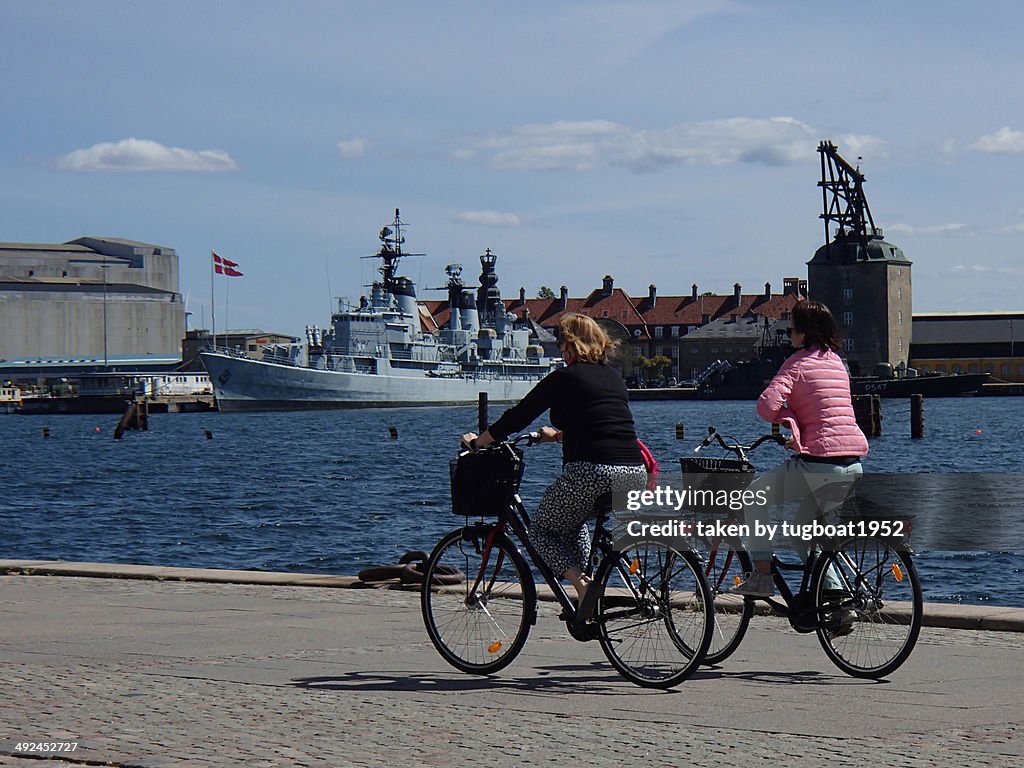 Ladies riding bicycles around harbour