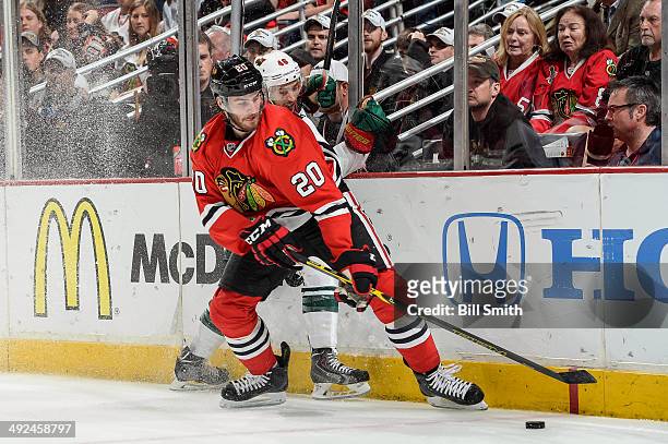 Brandon Saad of the Chicago Blackhawks checks Jared Spurgeon of the Minnesota Wild into the boards while chasing the puck in Game Five of the Second...