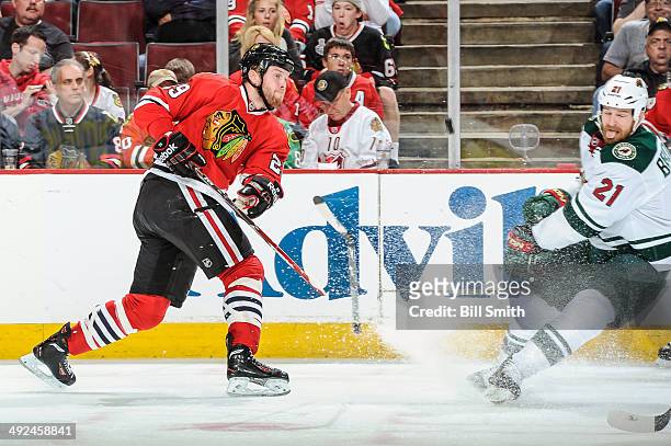 Bryan Bickell of the Chicago Blackhawks breaks his stick while shooting past Kyle Brodziak of the Minnesota Wild in Game Five of the Second Round of...