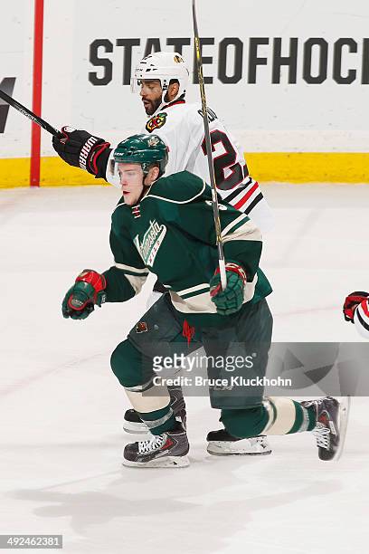 Charlie Coyle of the Minnesota Wild and Johnny Oduya of the Chicago Blackhawks skate to the puck during Game Six of the Second Round of the 2014...
