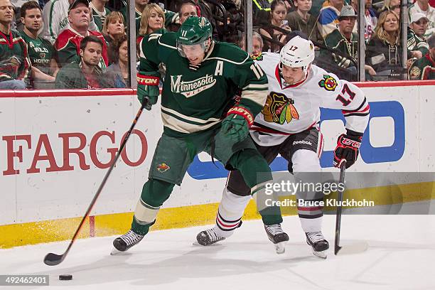 Zach Parise of the Minnesota Wild controls the puck with Sheldon Brookbank of the Chicago Blackhawks defending during Game Six of the Second Round of...