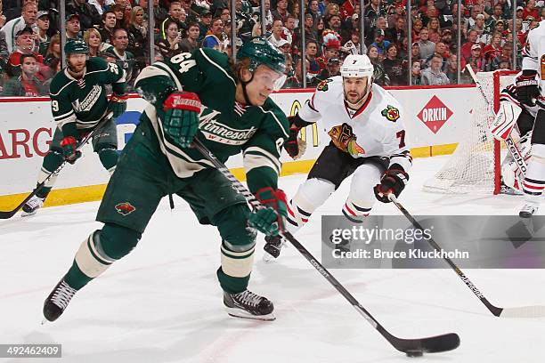 Mikael Granlund of the Minnesota Wild passes the puck with Brent Seabrook of the Chicago Blackhawks defending during Game Six of the Second Round of...