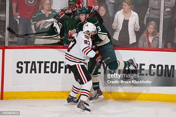 Johnny Oduya of the Chicago Blackhawks checks Charlie Coyle of the Minnesota Wild during Game Six of the Second Round of the 2014 Stanley Cup...