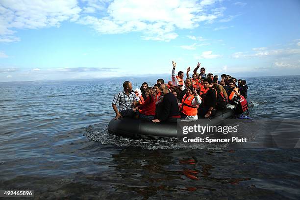 Raft carrying Syrian and Iraqi refugees arrives on the island of Lesbos from Turkey on October 13, 2015 in Mitilini, Greece. Dozens of rafts are...