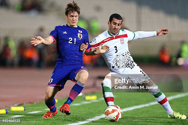 Ehsan Hajsafi and Sakai Gotoku in action during the international friendly match between Iran and Japan at Azadi Stadium on October 13, 2015 in...