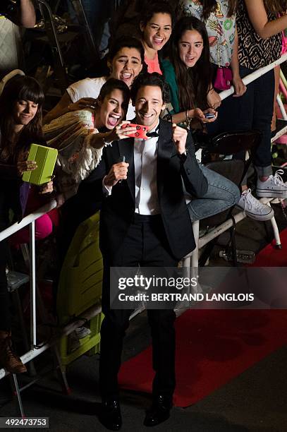 Actor Adrien Brody poses with fans as he arrives for the screening of the film "Coming Home at the 67th edition of the Cannes Film Festival in...