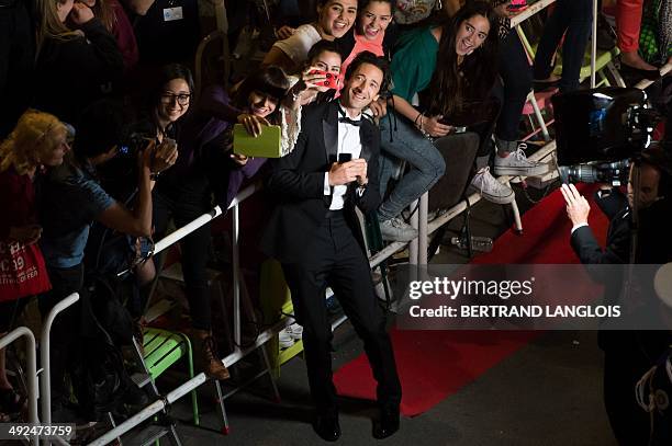 Actor Adrien Brody poses with fans as he arrives for the screening of the film "Coming Home at the 67th edition of the Cannes Film Festival in...