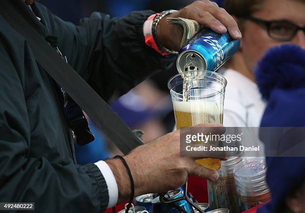 Budweiser vendor pours a beer prior to game four of the National League Division Series between the Chicago Cubs and the St. Louis Cardinals at...