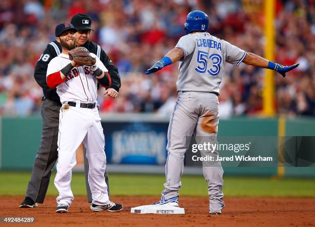 Melky Cabrera of the Toronto Blue Jays reacts after sliding safely into second base for a double in the third inning in front of Dustin Pedroia of...