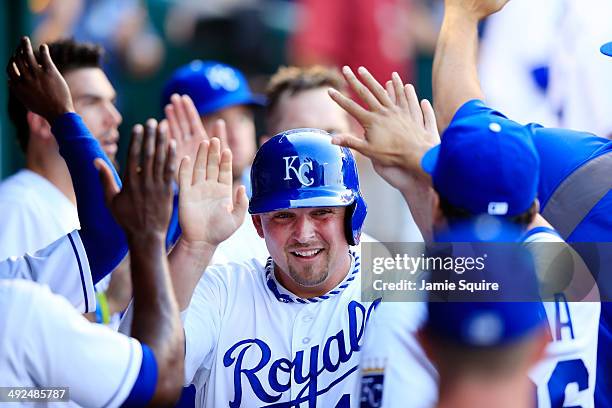 Kansas City Royals designated hitter Billy Butler is congratulated by teammates in the dugout after scoring during the game against the Chicago White...