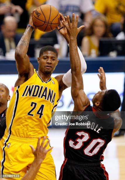 Paul George of the Indiana Pacers looks to pass as Norris Cole of the Miami Heat defends during Game Two of the Eastern Conference Finals of the 2014...