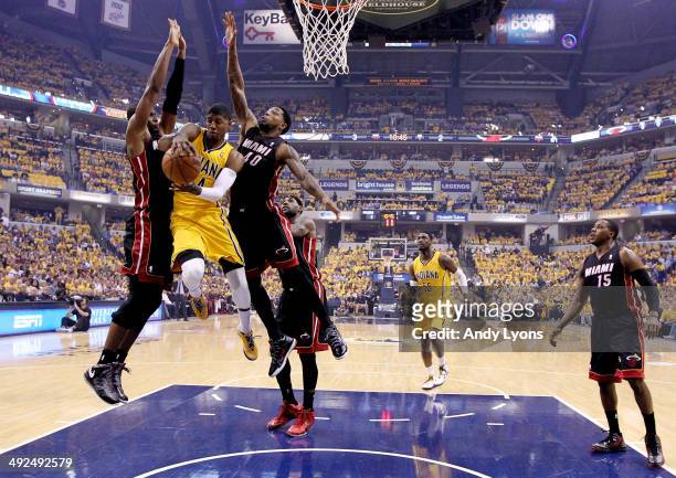 Paul George of the Indiana Pacers drives to the basket against Chris Bosh and Udonis Haslem of the Miami Heat during Game Two of the Eastern...