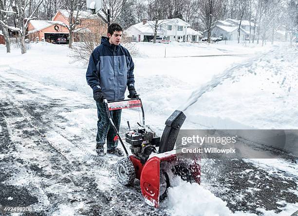 snowblower chores clearing snow from suburban driveway - sneeuwmachine stockfoto's en -beelden