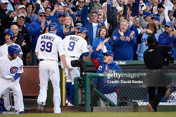 Javier Baez of the Chicago Cubs is congratulated by manager Joe Maddon of the Chicago Cubs after hitting a three-run home run in the second inning...