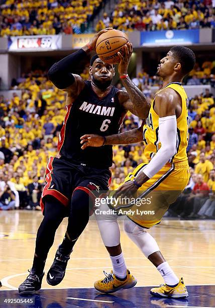 LeBron James of the Miami Heat goes to the basket as Paul George of the Indiana Pacers defends during Game Two of the Eastern Conference Finals of...