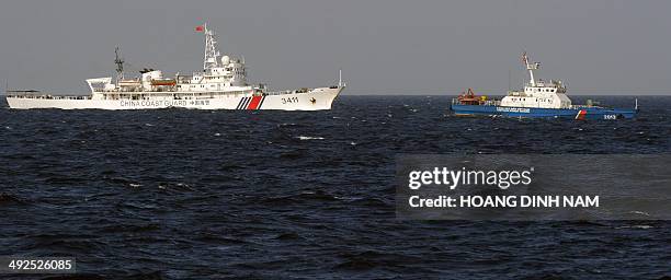 This picture taken from a Vietnam Coast Guard ship on May 14, 2014 shows a China Coast Guard ship chasing a Vietnam Coast Guard ship near to the site...