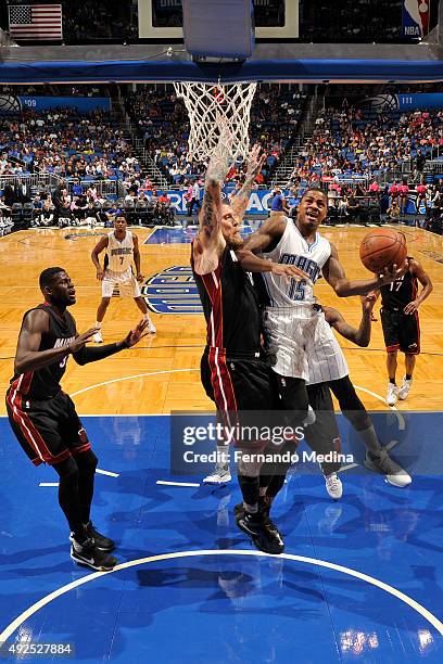 Keith Appling of the Orlando Magic drives to the basket against the Chris Andersen of the Miami Heat during a preseason game on October 13, 2015 at...