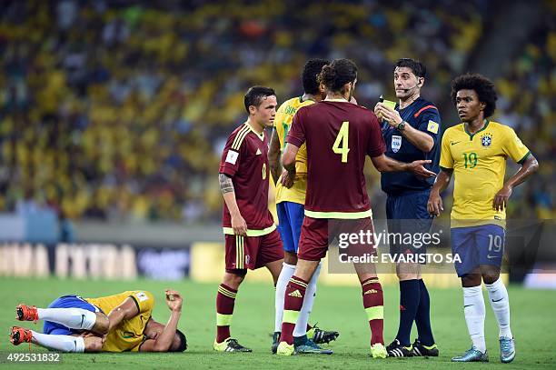 Uruguayan referee Dario Ubriaco shows the yellow card to Venezuela's Oswaldo Vizcarrondo for fouling Brazil's Ricardo Oliveira during the Russia 2018...