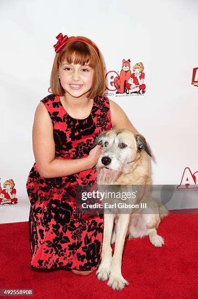 Actor Issie Swickle and lead dog Macy pose for a photo at the premiere Of "Annie" at the Pantages Theatre on October 13, 2015 in Hollywood,...