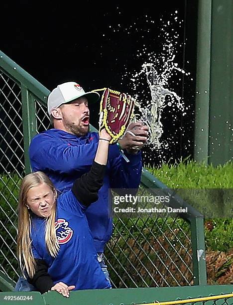 Fans of the Chicago Cubs try to catch a home run ball hit by Stephen Piscotty of the St. Louis Cardinals in the 1st inning during game four of the...