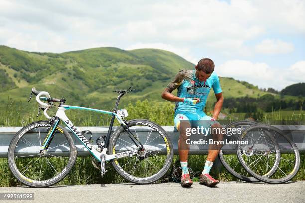 Andrey Zeits of Kazakhstan and Astana sits on the road barrier awaiting assistance after a crash during the eleventh stage of the 2014 Giro d'Italia,...