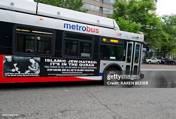 Metro bus, featuring a controversial ad, drives on a street in Washington, DC on May 21, 2014. Bus-ads linking "Islamic Jew-hatred" Islam with Adolf...