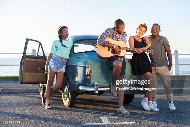 african hipster jamming to a tune - four friends in car stock pictures, royalty-free photos & images