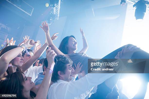 woman diving into the crowd at a concert - crowdsurfing stockfoto's en -beelden