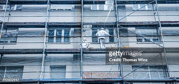 painters on a scaffolding - scaffolding stock pictures, royalty-free photos & images