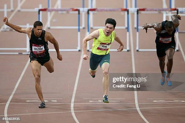 Chinese hurdler Xie Wenjun crosses the finishing line as Ryan Wilson and Ray Stewart of United States followed during the Men's 110-meter hurdles of...