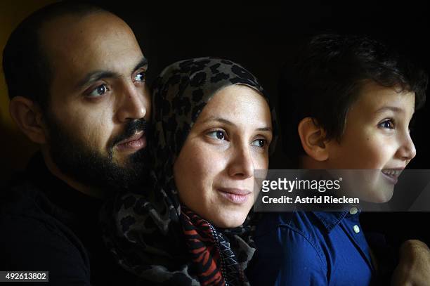 Syrian refugees Wael Al-Awis his wife Reem Haskour and their son Ali Al-Awis pose for a portrait photograph inside the room of the basement at the...