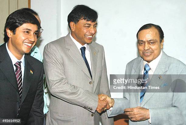 Chairman of ArcelorMittal Lakshmi N Mittal shakes hand with Union Minister for Petroleum and Natural Gas Murali Deora as his son Aditya Mittal of...