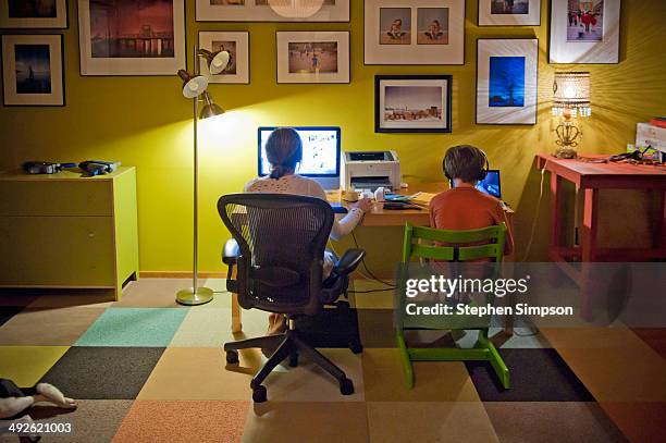 Siblings At The Computer Table In The Living Room High-Res Stock Photo
