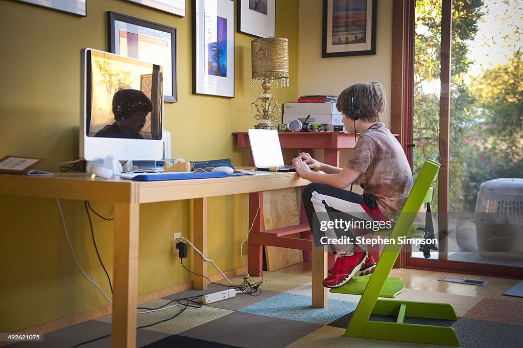 Boy at laptop at living room computer table