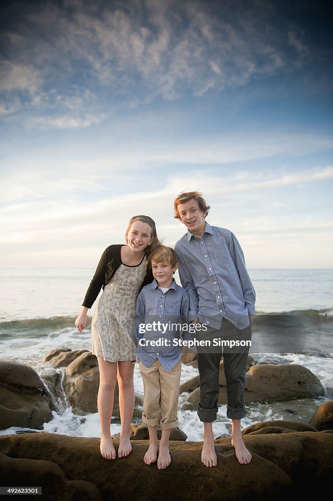 Portrait, siblings on a seaside boulder