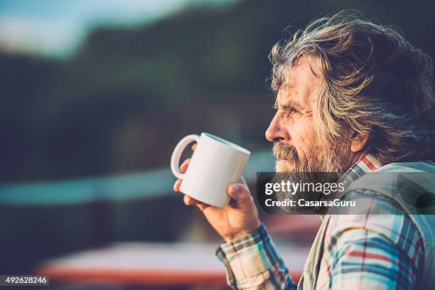 senior man drinking a coffee or a tea outdoors, close-up - drinking coffee outside stock pictures, royalty-free photos & images