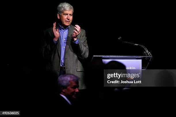 Michigan Governor Rick Snyder applauds JP Morgan Chase CEO Jamie Dimon during a luncheon May 21, 2014 in Detroit, Michigan. Jamie Dimon announced...