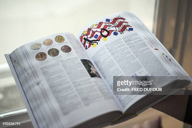 Woman holds an open copy of the newly printed 2015 edition of the French "Petit Larousse" dictionary, on May 21 in Paris. The "Petit Larousse" is...