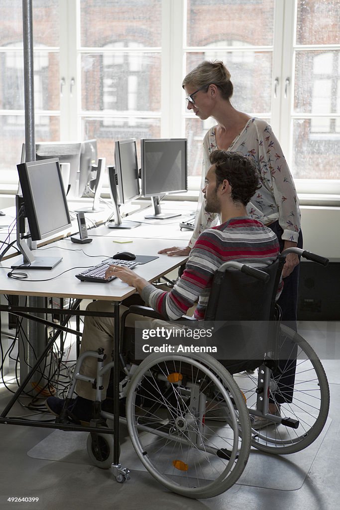 Man and woman working on computer in office