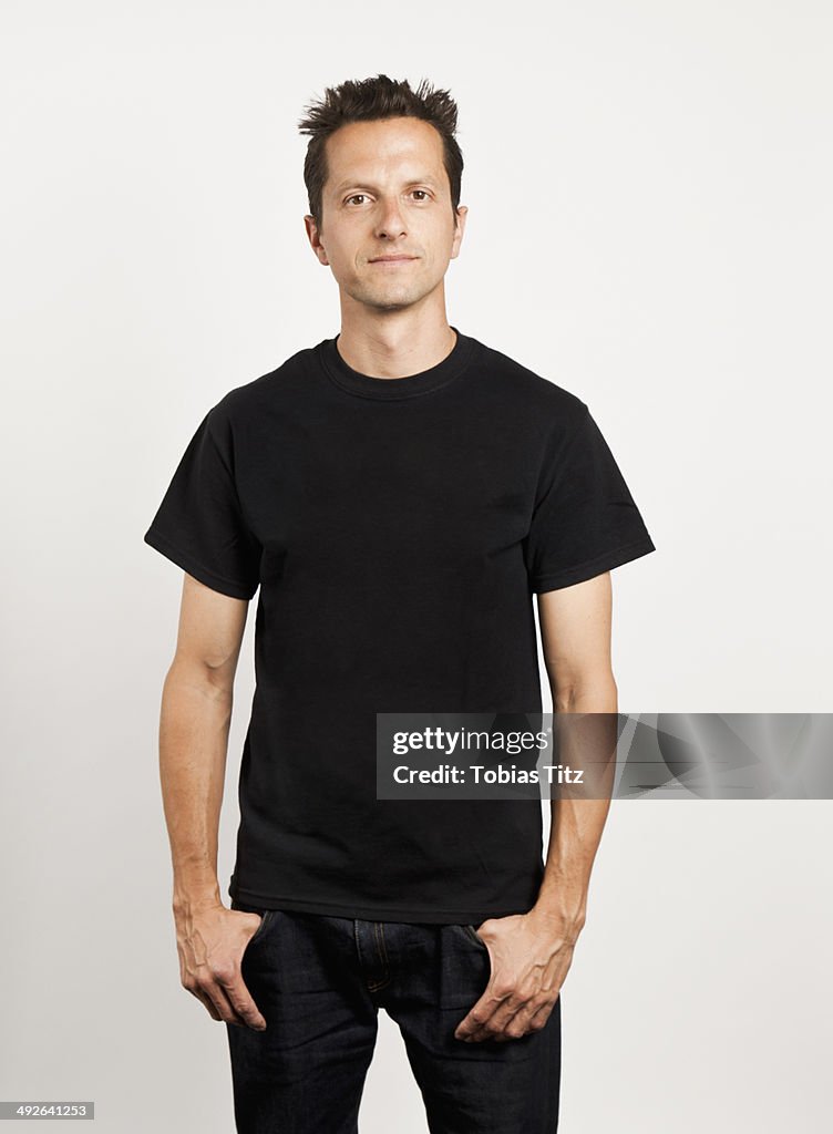 Portrait of young man standing against white background