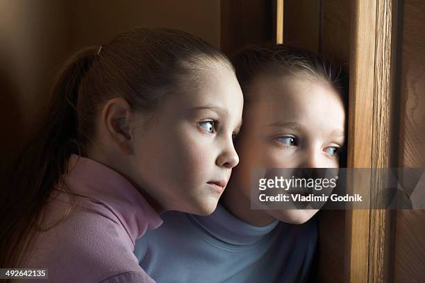two girls eavesdropping on door, close-up - lauschen stock-fotos und bilder