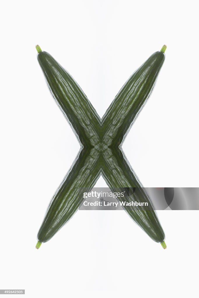 A digital composite of mirrored images of cucumbers in the shape of an X