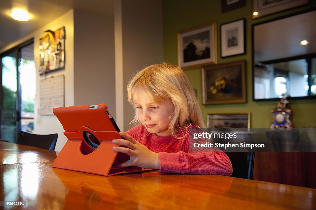 Young girl working/playing on her tablet computer